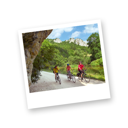 Bild Radfahren Drei Personen fahren nebeneinander auf einen Kiesweg mit dem Fahrrad durch das Donautal